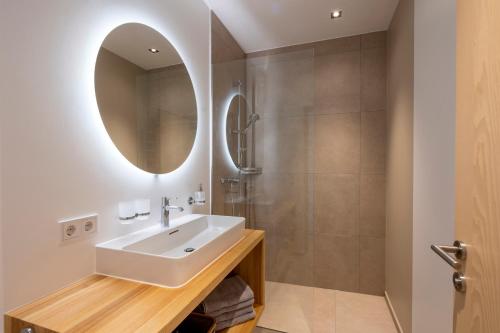 uma casa de banho com um lavatório e um chuveiro em am Greben Apartments drei - vier - fünf em Bezau