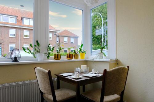 einen Tisch und Stühle in einem Zimmer mit Fenster in der Unterkunft Haus Magdalene in Bad Schwartau