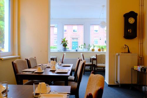 a dining room with tables and chairs and a clock at Haus Magdalene in Bad Schwartau