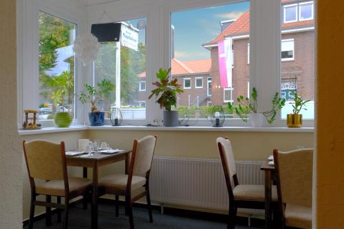 a dining room with a table and chairs and windows at Haus Magdalene in Bad Schwartau