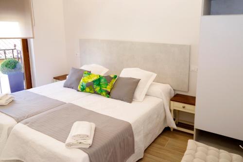 a bedroom with a large white bed with towels on it at vallespin 43 parking, wifi in Ávila