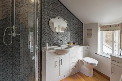 a bathroom with a toilet and a sink and a shower at Cow and Cockle - quirky cottage in the centre of Deal in Deal