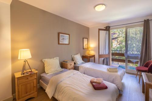 1 dormitorio con 2 camas y ventana en appartement paradiso en Saint-Gervais-les-Bains