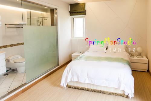 a bedroom with a bed and a bathroom with a shower at Zhuyuan Ju B&B in Yuanshan