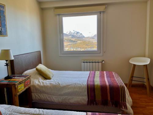 een slaapkamer met 2 bedden en een raam bij MLH2 Departamento in Ushuaia