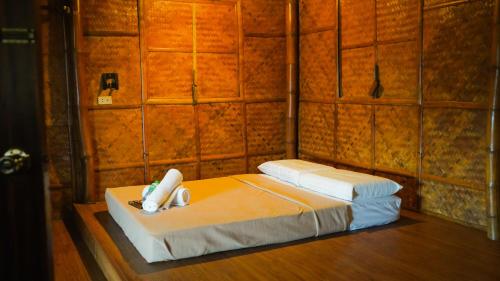 a room with a bed with a phone on it at Hijo Resorts Davao in Tagum
