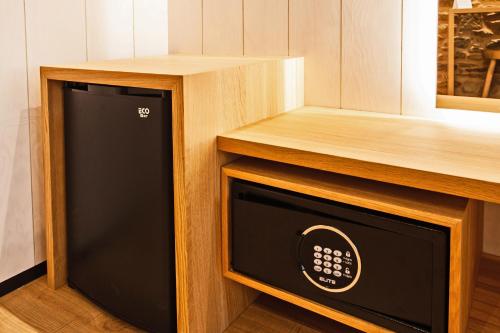 a microwave oven in a kitchen with a wooden cabinet at Hotel Plaza Obradoiro by Bossh! Hotels in Santiago de Compostela