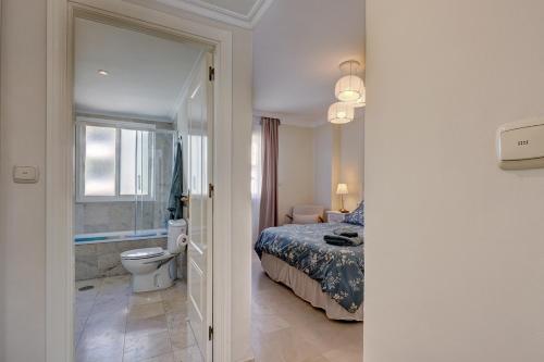 een slaapkamer met een bed en een badkamer met een toilet bij Lujo en banana beach primera línea de playa in Marbella