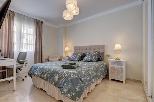um quarto com uma cama, uma secretária e uma janela em Lujo en banana beach primera línea de playa em Marbella