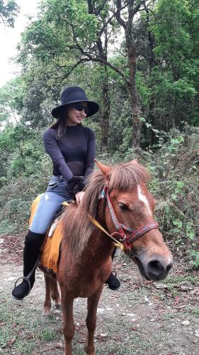 a woman riding on the back of a horse at Dulcify cottage sarangkot in Pokhara
