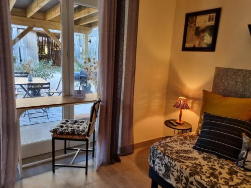Schlafzimmer mit einem Bett, einem Schreibtisch und einem Fenster in der Unterkunft Au Vieux Séchoir in Prudhomat