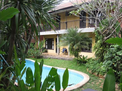 a resort with a swimming pool in front of a building at Little Eden Guesthouse in Pang Mapha