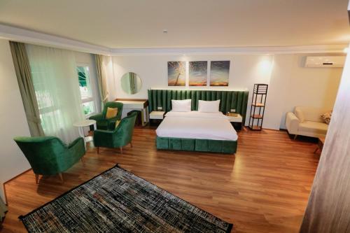 um quarto de hotel com uma cama e cadeiras verdes em Grand Luxury em Yalova