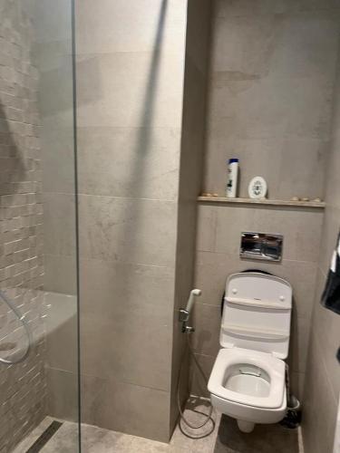 a bathroom with a toilet and a glass shower stall at Superbe Appartement kantaoui sousse in Sousse