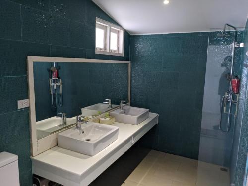 班拉克海灘的住宿－Bann Kanchana Bangrak，绿色浴室设有2个水槽和淋浴。