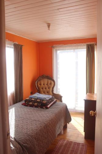 1 dormitorio con 1 cama con paredes y ventanas de color naranja en cabaña en Pichilemu, en Pichilemu