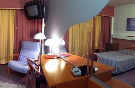 um quarto de hotel com uma secretária e uma cama em Hotelli Haapakannel em Haapavesi
