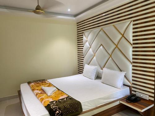um quarto com uma cama e uma cabeceira em madeira em Ditto Room Hotel Golden Sun, New Digha em Digha