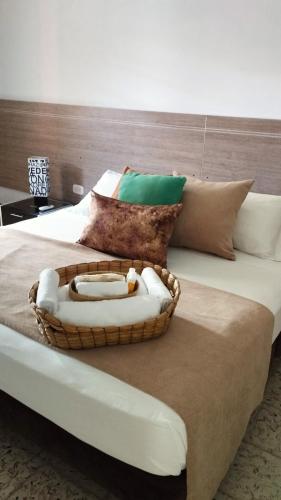 a basket of towels sitting on top of a bed at Casa de Pinos Hotel Boutique in Bucaramanga