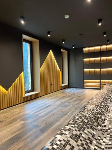 a large room with a wooden floor and windows at Rtanj Kopaonik Eco Resort & Spa in Kopaonik