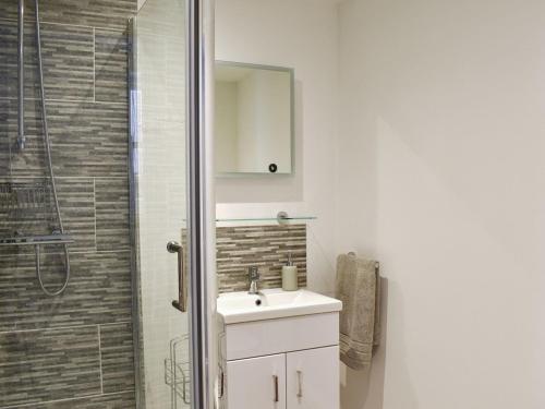a bathroom with a sink and a shower with a mirror at Harbour Retreat in Ramsgate