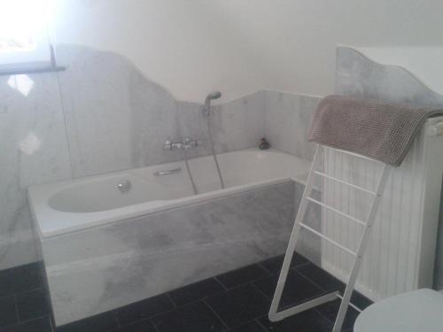 ein Bad mit einer Badewanne und einem Handtuch auf einer Leiter in der Unterkunft Villa Marie Oli in Nieuwpoort