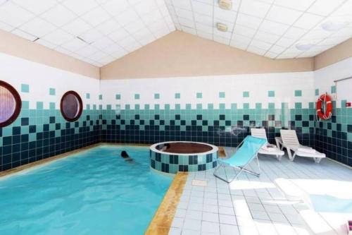 a pool in a room with a person in the water at Samoens - E12 in Samoëns