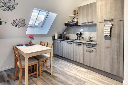 a kitchen with a table and chairs and a counter at Studio'Moment Saint-Omer Centre in Saint-Omer