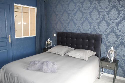 a bedroom with a large bed with blue walls at Althéa, gîte de charme et bien être in Fontenay-le-Comte