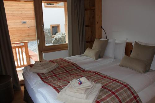 a bedroom with a large bed with towels on it at Chalet Binna in Zermatt