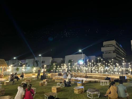 a group of people sitting in a park at night at Kings House Apec Condotel Phú Yên in Tuy Hoa