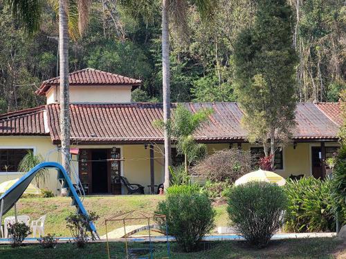 una casa con un parque infantil delante de ella en Pousada Green Valley, en São Roque