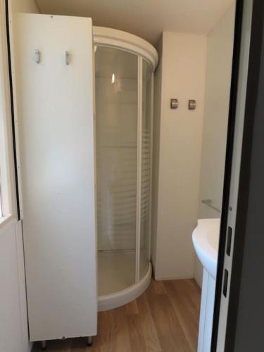 une salle de bain blanche avec une douche et un lavabo dans l'établissement Mobile home 6-pers Camping Leï Suves-Côtes d'Azur-including airco, à Roquebrune-sur Argens