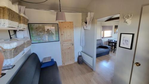 a living room with a blue couch in a tiny house at Hekla Nordicabin - Wild Cottage in Hella