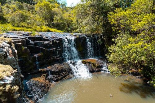 a waterfall in the middle of a pool of water at Chalés Rota das Cachoeiras in Urupema