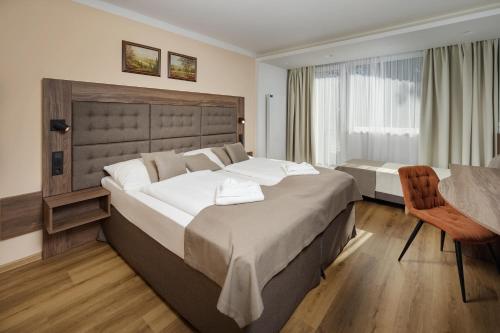 Cette chambre comprend 2 lits et une table. dans l'établissement Wellness Hotel Astra, à Špindlerův Mlýn