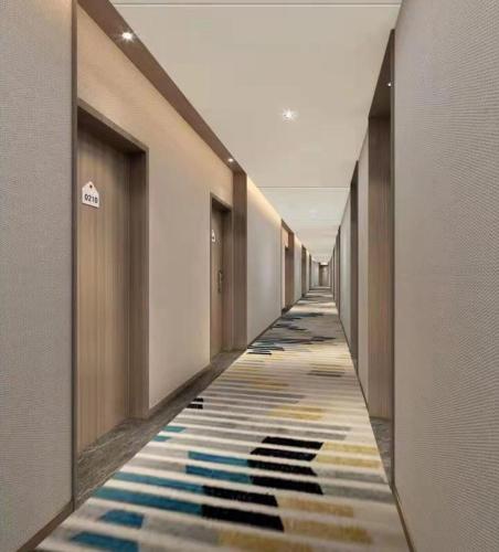 a hallway with a colorful carpet in a building at Holiday Inn Express Tianjin Binhai by IHG in Binhai