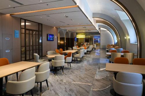 a row of tables and chairs in a restaurant at Holiday Inn Express Tianjin Binhai by IHG in Binhai