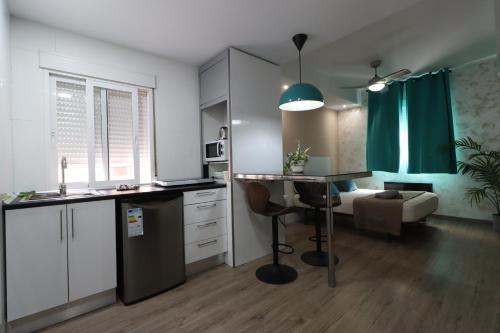 een keuken met witte kasten en een bureau in een kamer bij Carthago Suites in Cartagena