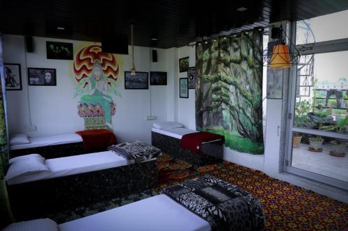 ein Zimmer mit Sofas und Gemälden an den Wänden in der Unterkunft Hotel Zoola Palace in Pushkar