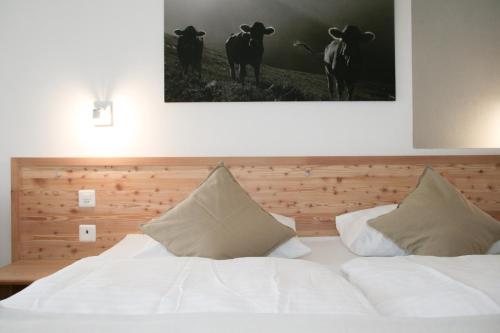 a bedroom with a bed with two cows on the wall at Hotel Solaria in Bivio