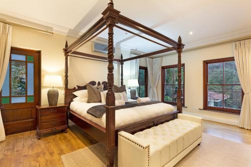 1 dormitorio con cama con dosel y sofá en Lyonesse House - No Load Shedding, en Ciudad del Cabo