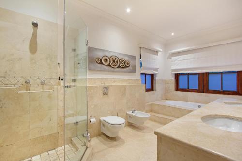y baño con ducha, aseo y lavamanos. en Lyonesse House - No Load Shedding, en Ciudad del Cabo