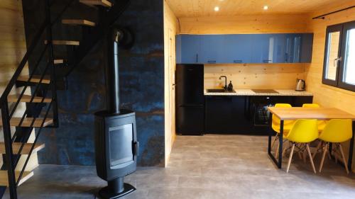 Il comprend une cuisine équipée d'une cuisinière et d'une table avec des chaises jaunes. dans l'établissement Domek nad Nieliszem, à Nielisz