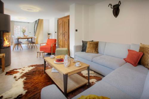 ein Wohnzimmer mit einem Sofa und einem Tisch in der Unterkunft Chalet Ysopi - OVO Network in Saint-Jean-de-Sixt