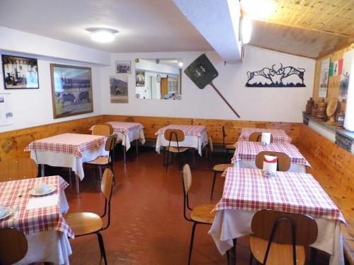 Hotel Mochettaz في أَويستا: غرفة طعام مع طاولات وكراسي حمراء وبيضاء