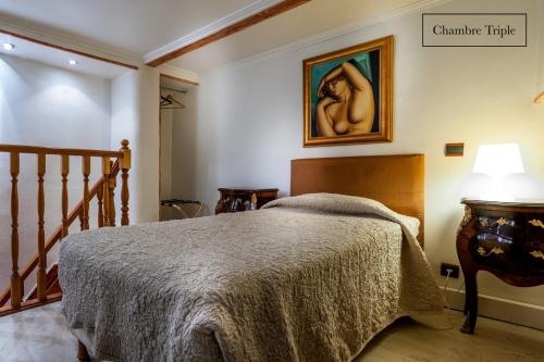 a bedroom with a bed and a painting on the wall at Grand Hôtel du Bel Air in Paris