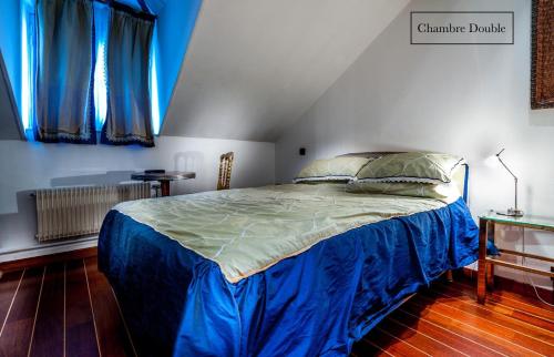 a bedroom with a bed with blue sheets and blue curtains at Grand Hôtel du Bel Air in Paris