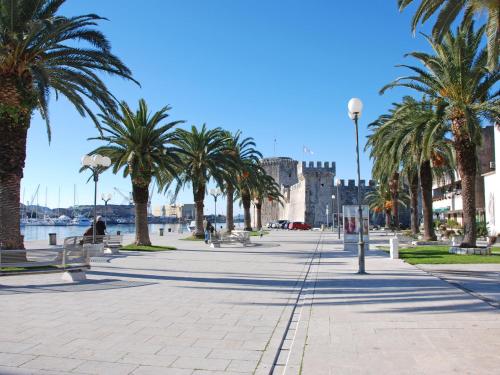 a city street with palm trees and a building at Studios Magnolia in Trogir