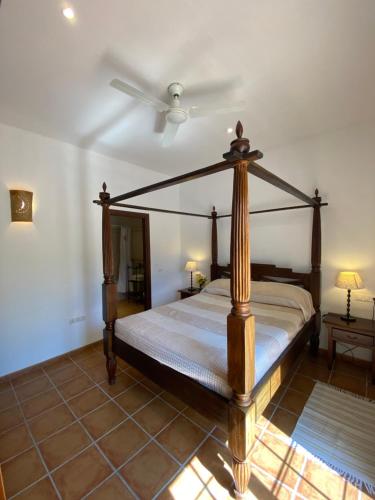 een slaapkamer met een hemelbed en een ventilator bij Padre Aviles in Olías